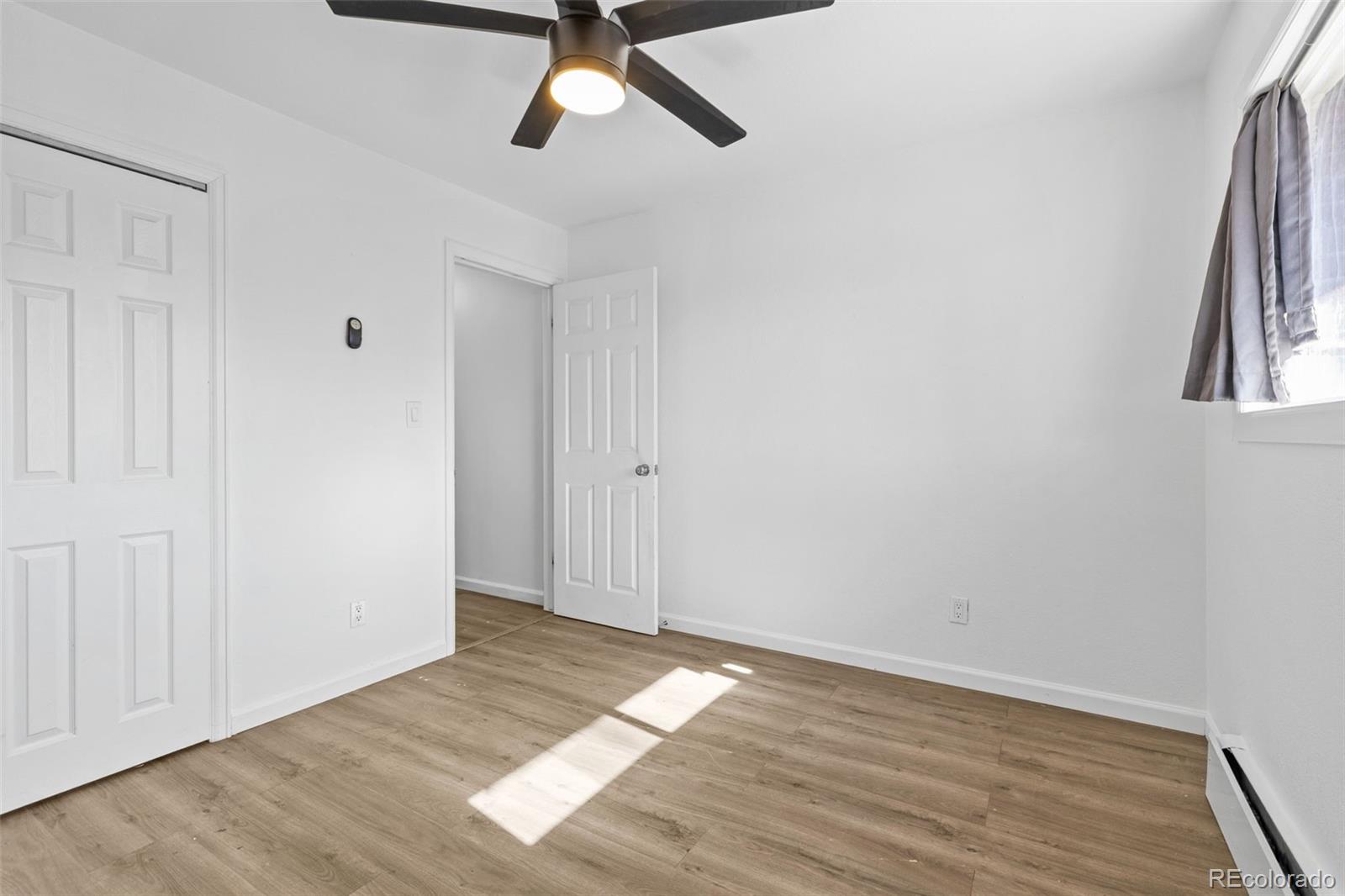1630 Chester Street Aurora, CO 80010 - Photo 30 of 31 an empty room with wooden floor and windows