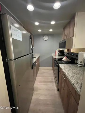 a kitchen with stainless steel appliances granite countertop a sink stove and refrigerator