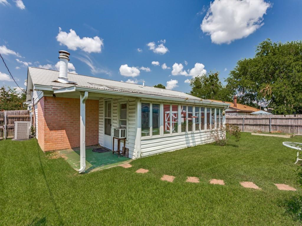 1216 Manning Street Benbrook, TX 76126 - Photo 21 of 26 Rear view of house featuring brick siding, a patio, a chimney, a sunroom, and a metal roof