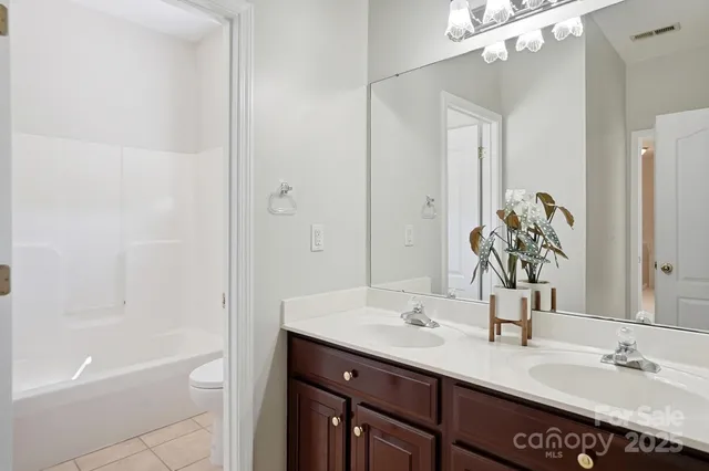 a bathroom with a granite countertop sink a toilet and shower