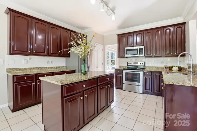 a kitchen with stainless steel appliances granite countertop a stove microwave and cabinets