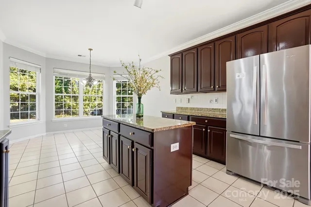 a kitchen with stainless steel appliances granite countertop a stove a refrigerator and a cabinets