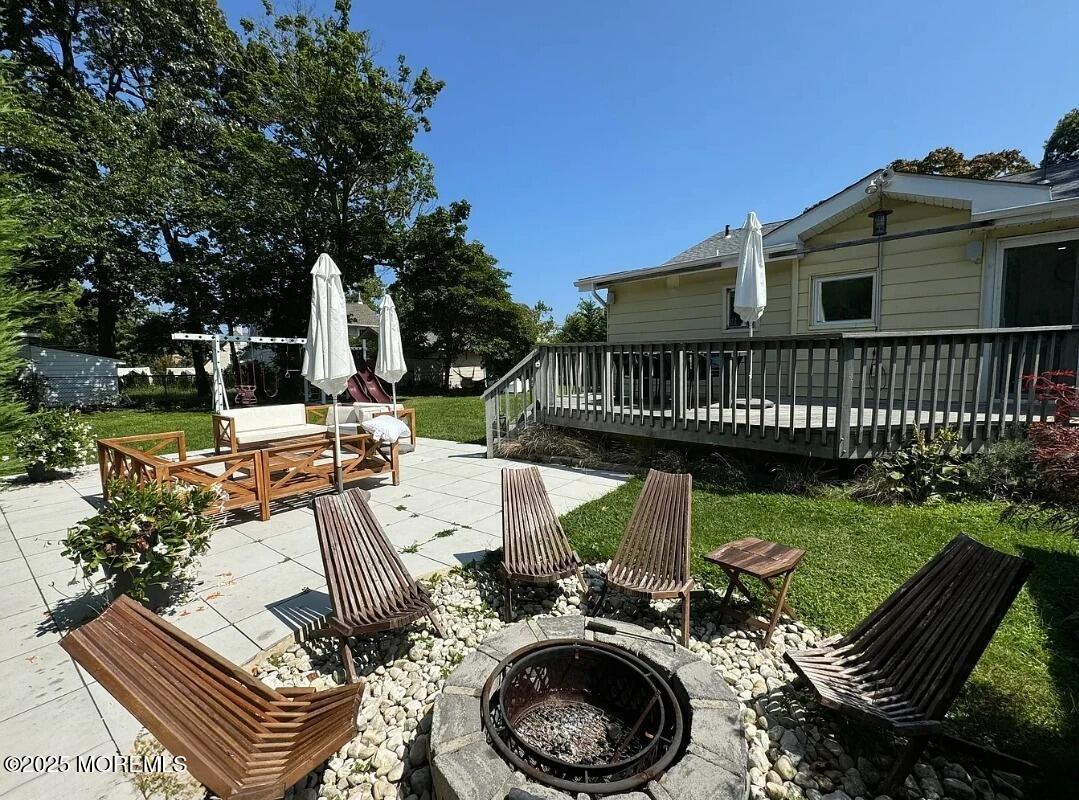184 Ridgewood Avenue Oakhurst, NJ 07755 - Photo 15 of 16 a view of a patio with a table chairs and a small yard