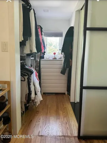 a view of walk in closet with clothes and shoes