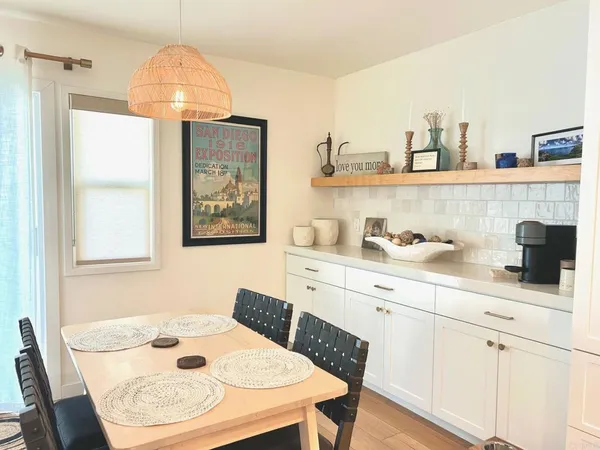 a kitchen with stainless steel appliances a table and chairs in it