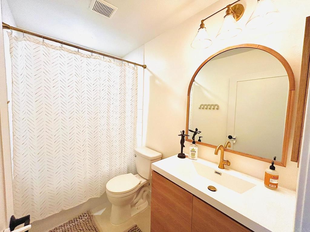 215 Countryhaven Road Encinitas, CA 92024 - Photo 6 of 12 a bathroom with a sink a toilet and a mirror