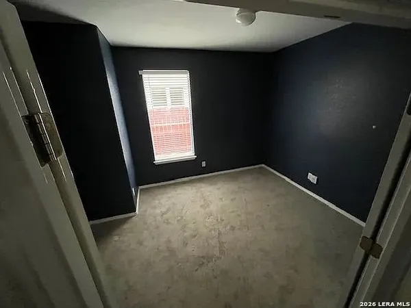 en empty room with windows and ceiling fan