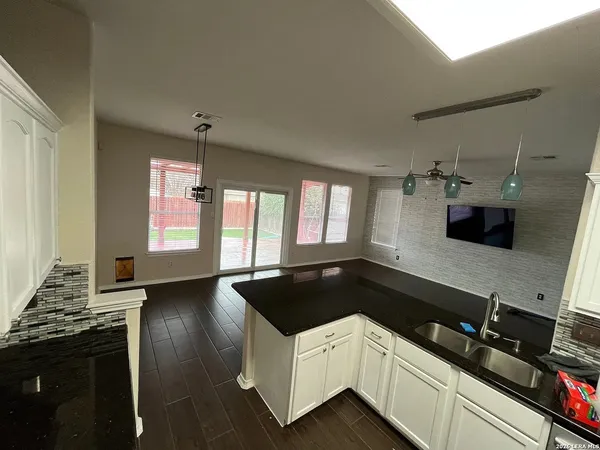 a kitchen with granite countertop a sink a stove and cabinets