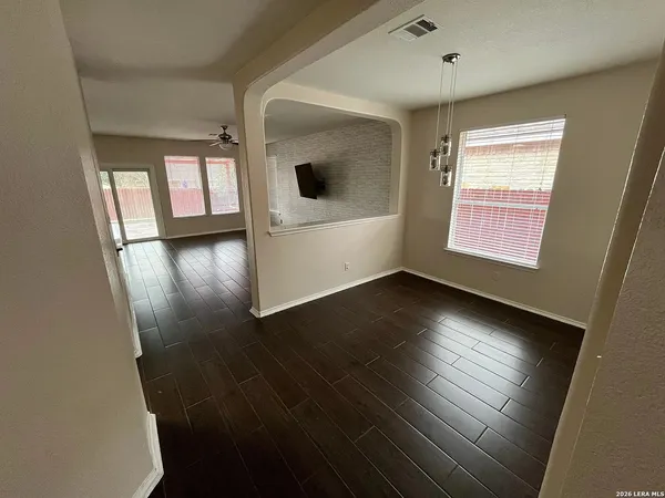 an empty room with wooden floor and windows