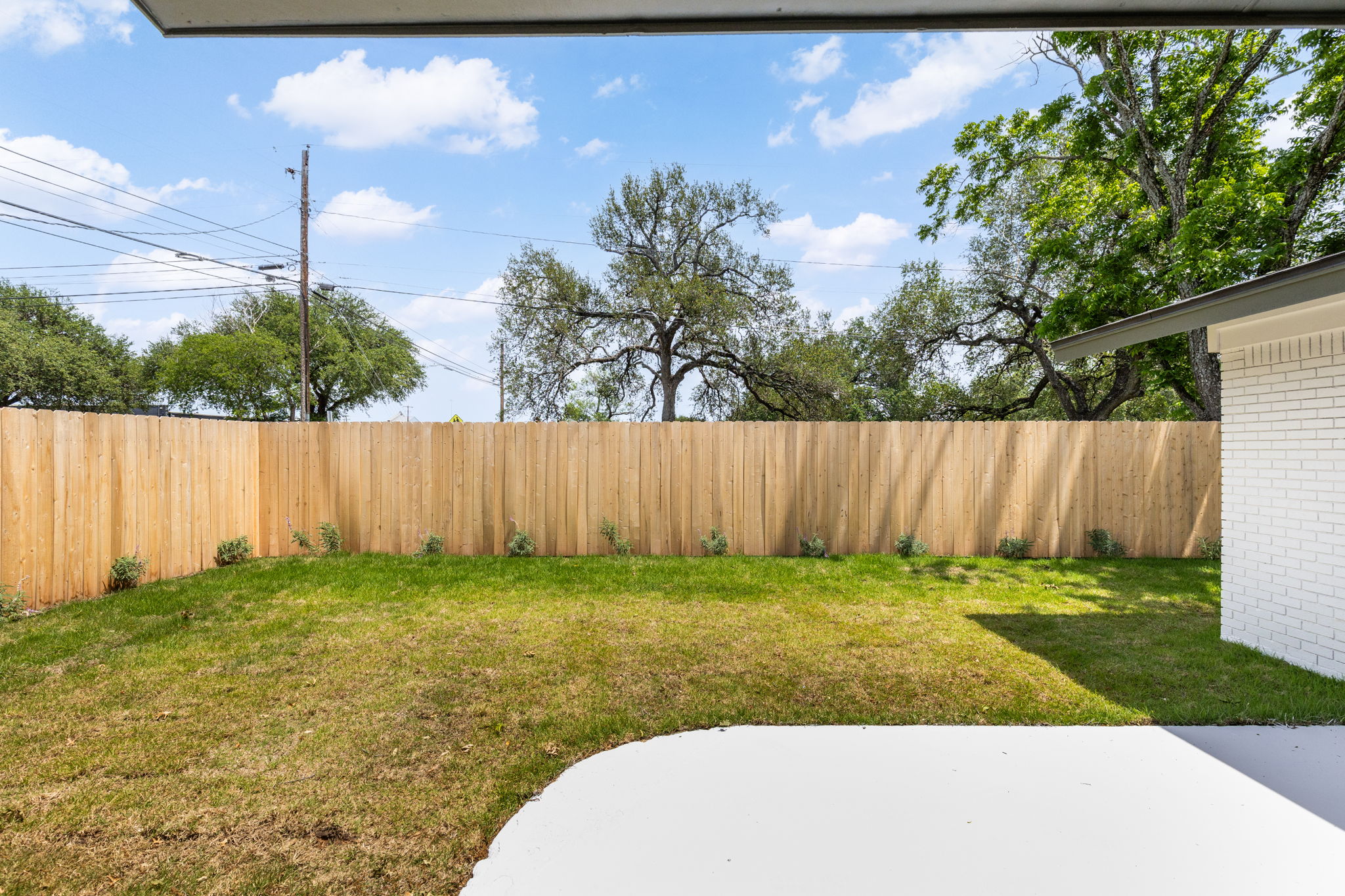 4501 Pack Saddle Pass Austin, TX 78745 - Photo 35 of 37 Private backyard featuring a newly installed wooden privacy fence, a manicured lawn, and a concrete patio area