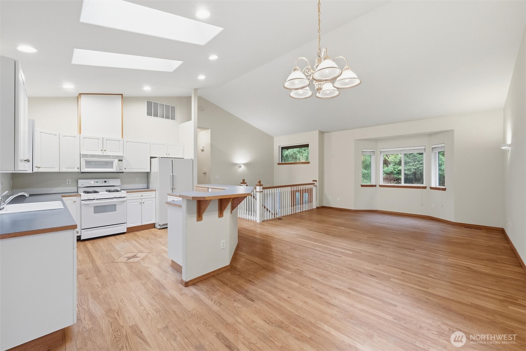 36 Holly View Way Bellingham, WA 98229 - Photo 7 of 40 a large white kitchen with kitchen island a stove a sink dishwasher and white cabinets with wooden floor