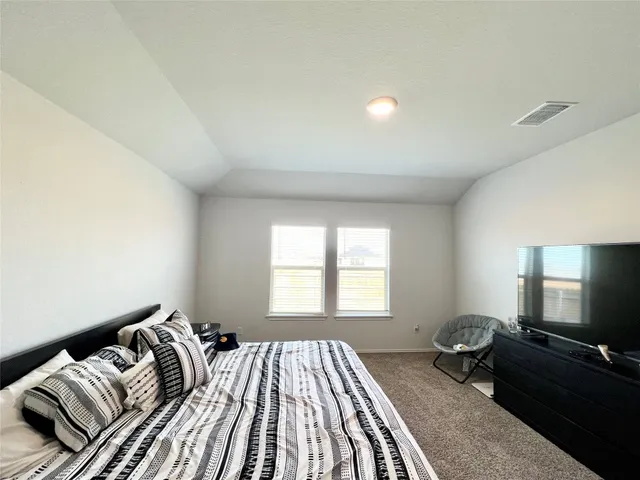 a bedroom with a large bed and a window