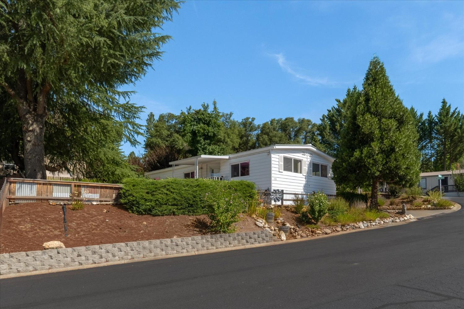 a front view of a house with a yard and trees