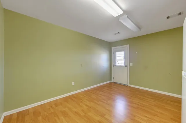 a view of an empty room with wooden floor
