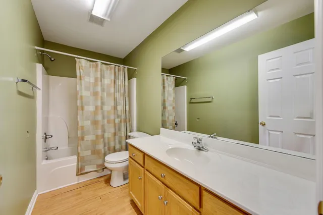 a bathroom with a granite countertop sink a toilet and shower
