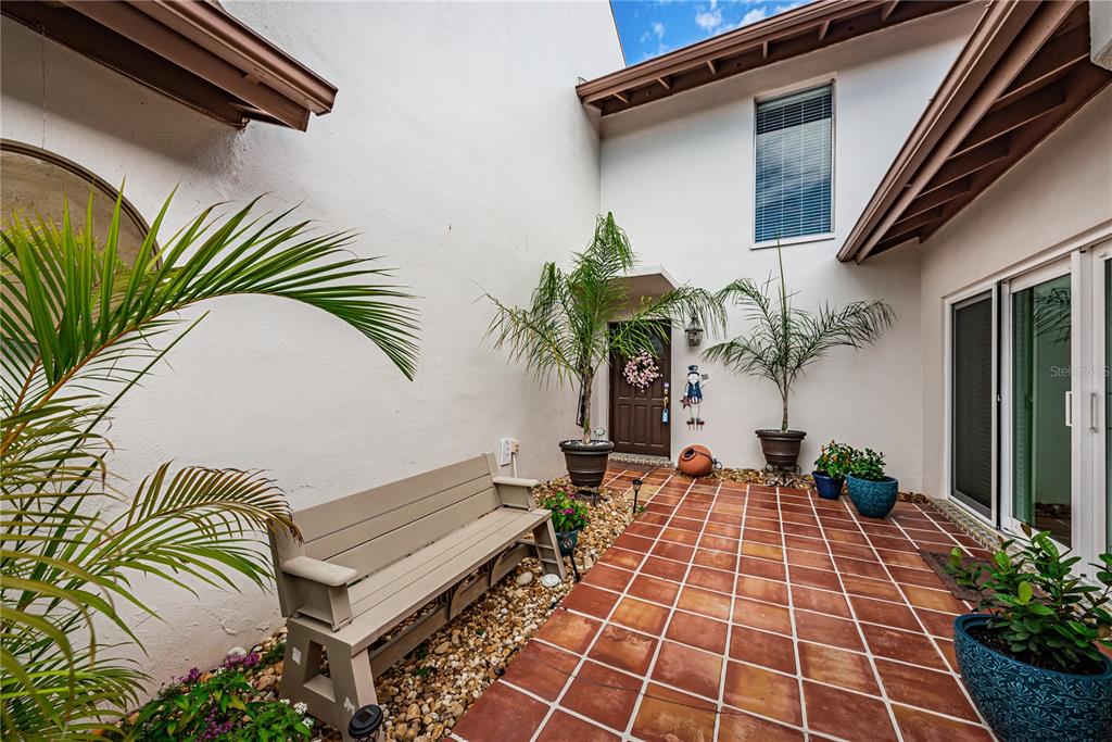 7501 Cumberland Road, Unit 23 Largo, FL 33777 - Photo 1 of 1 a view of a backyard with plants and a potted plant
