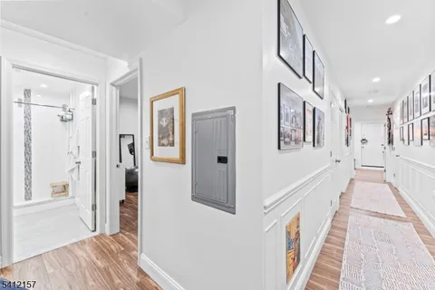 a view of a hallway with wooden floor and staircase