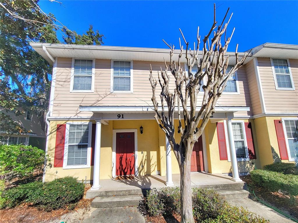 a front view of a house with a tree