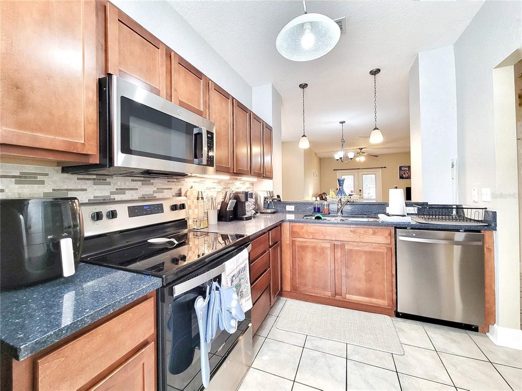 2508 Southwest 35th Place, Unit P91 Gainesville, FL 32608 - Photo 16 of 33 a kitchen with stainless steel appliances granite countertop a stove a sink and a microwave