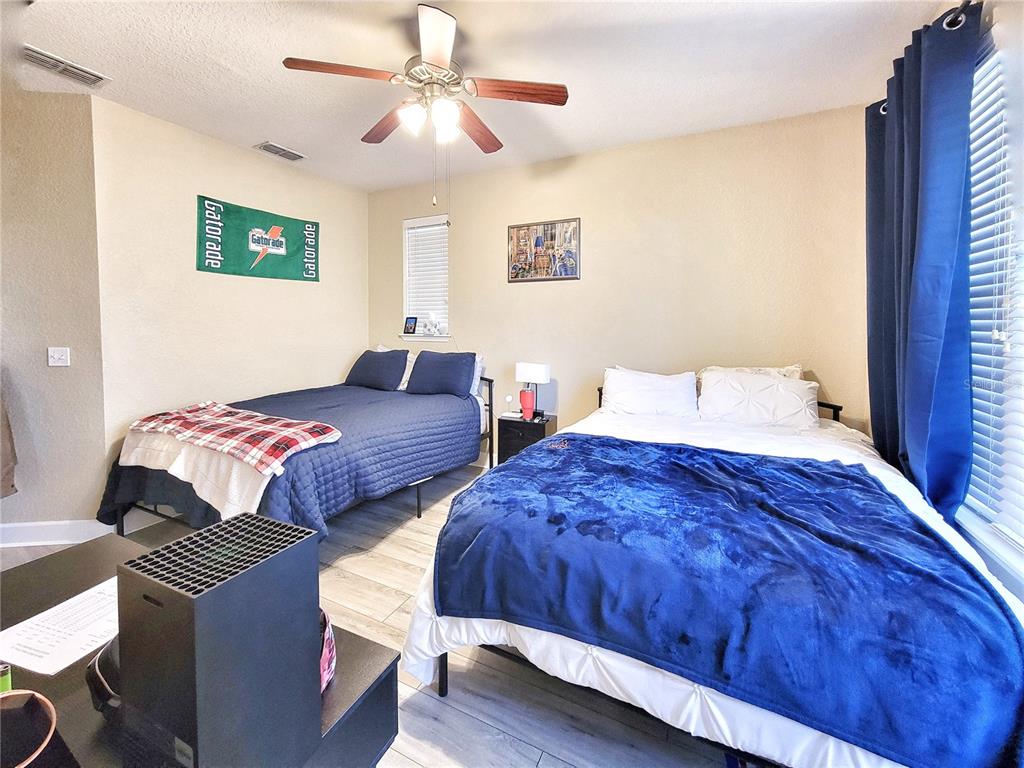 2508 Southwest 35th Place, Unit P91 Gainesville, FL 32608 - Photo 24 of 33 a bedroom with two beds and a chandelier
