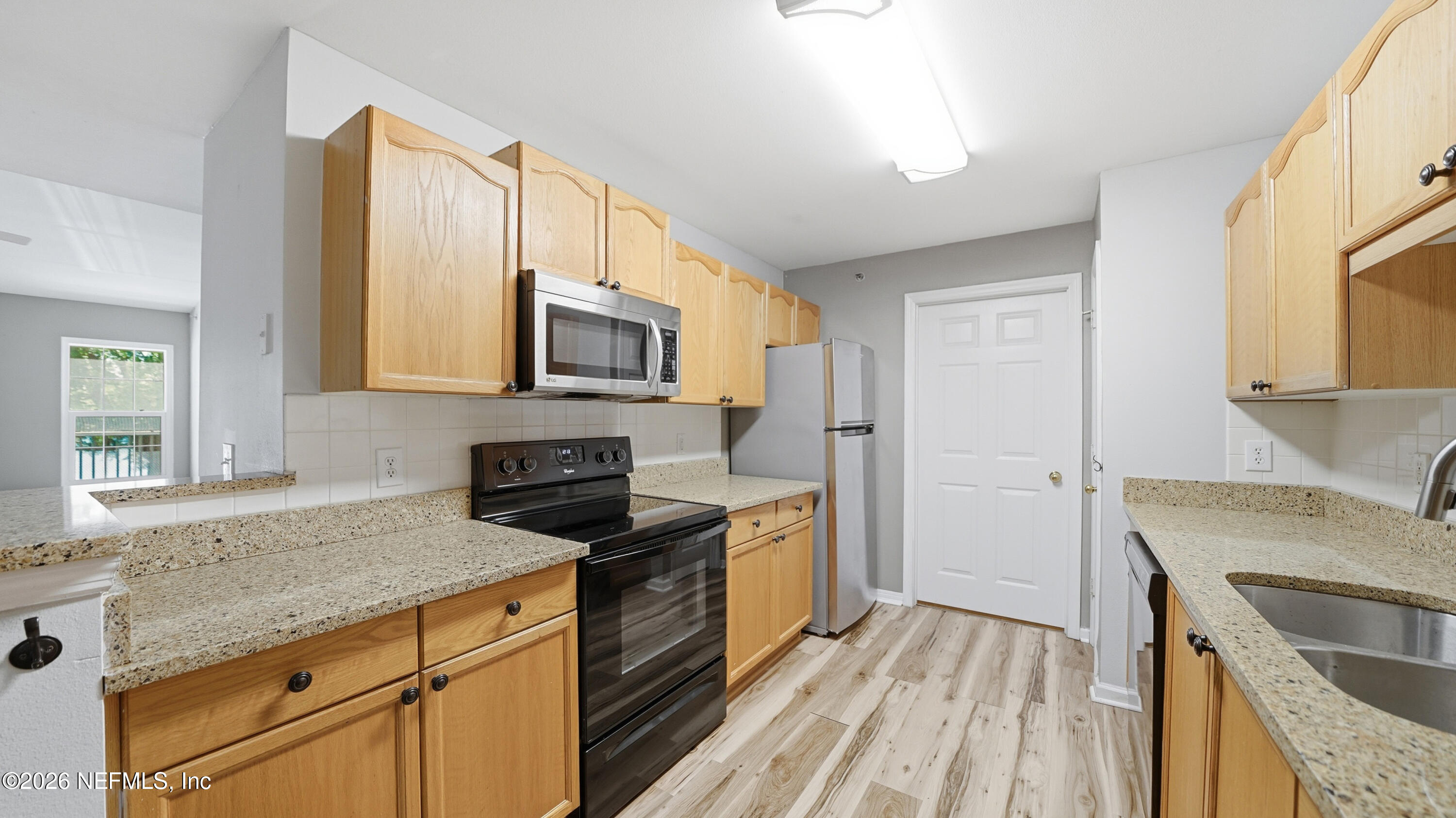 23699 Bahama Point, Unit 1126 Fernandina Beach, FL 32034 - Photo 13 of 50 a kitchen with granite countertop a sink stove and refrigerator