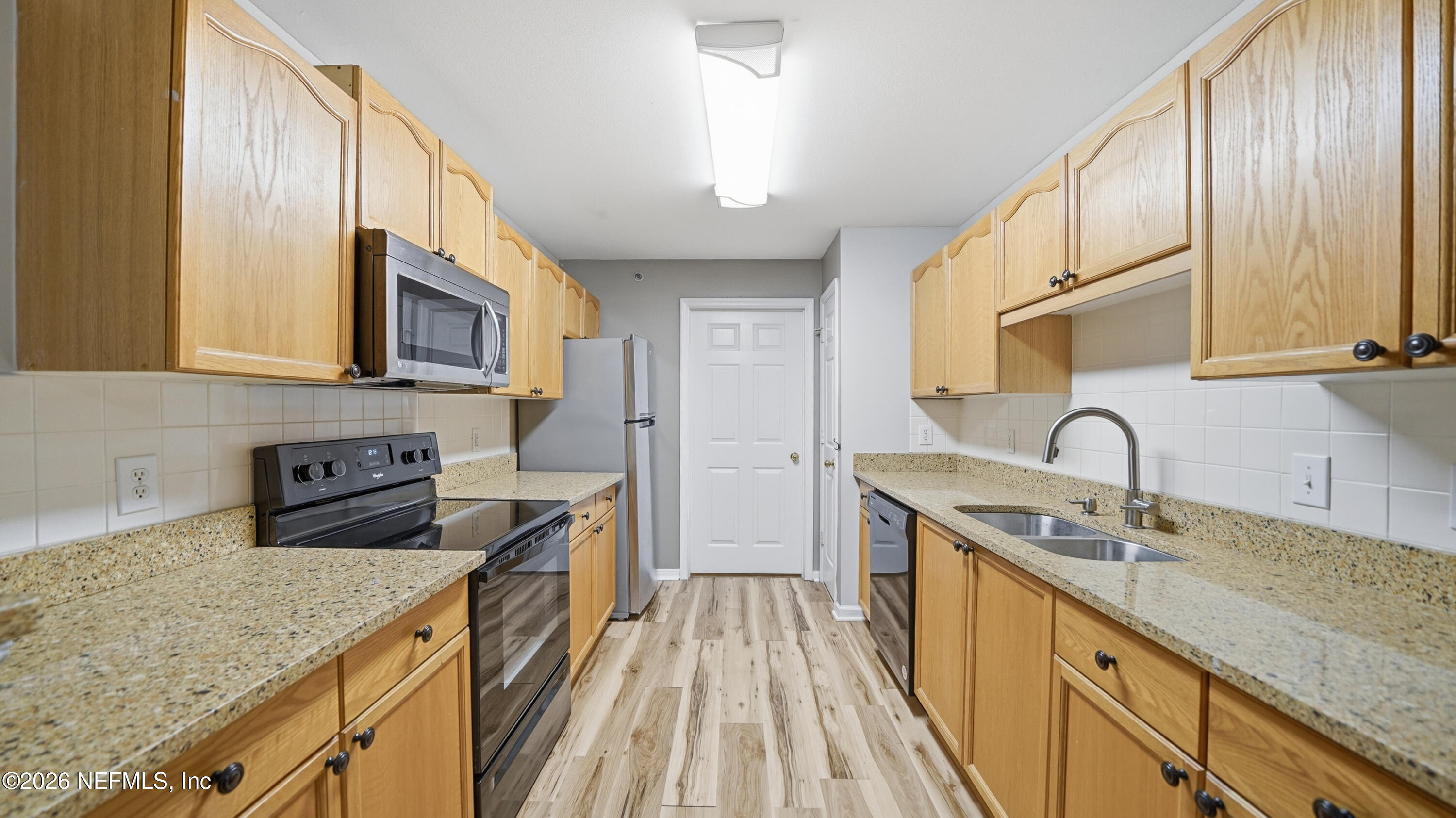 23699 Bahama Point, Unit 1126 Fernandina Beach, FL 32034 - Photo 14 of 50 a kitchen with sink a stove and cabinets