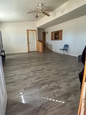 a room with a wooden floor and ceiling fan