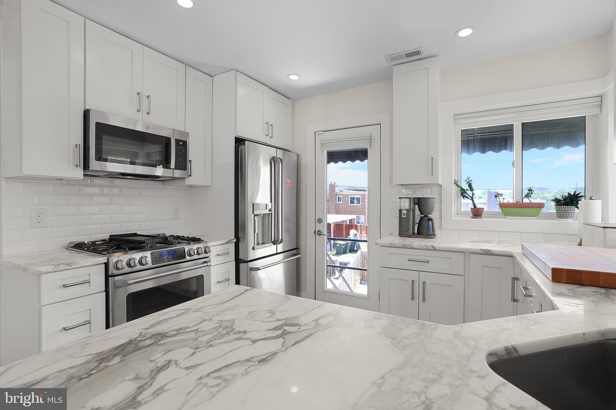 1225 Gallatin Street Northeast Washington, DC 20017 - Photo 7 of 28 a kitchen with white cabinets and stainless steel appliances