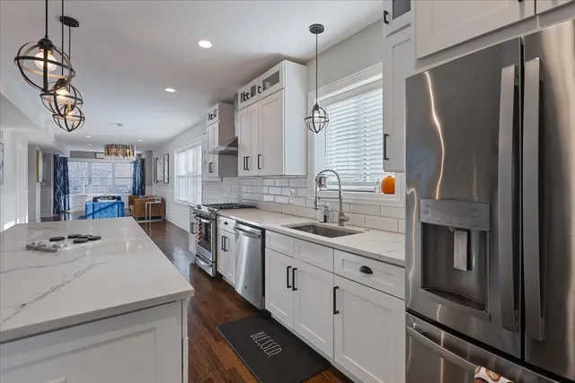 a kitchen with white cabinets and appliances