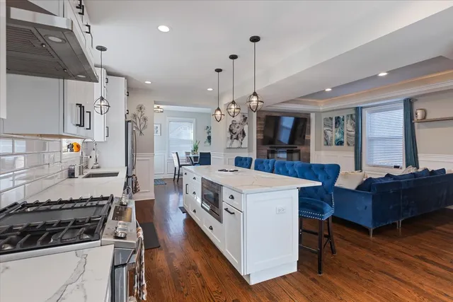 a kitchen with a stove a refrigerator and wooden floor