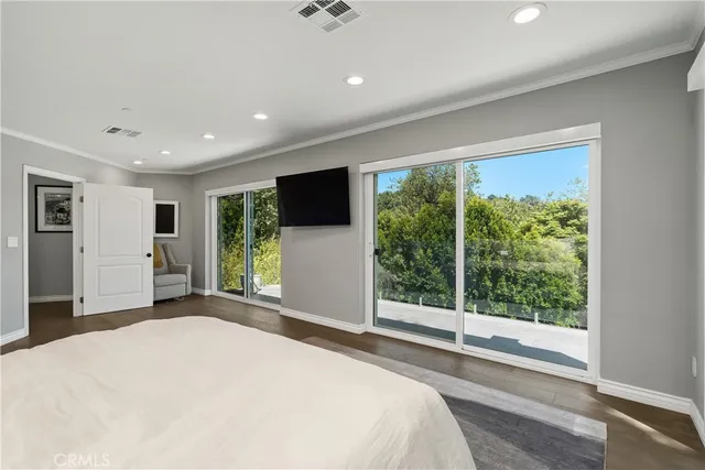 a bedroom with a large bed and a flat screen tv