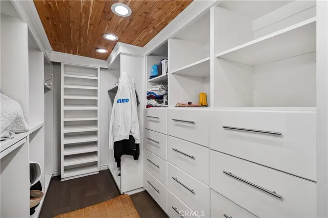 a view of walk in closet with clothes and shoes