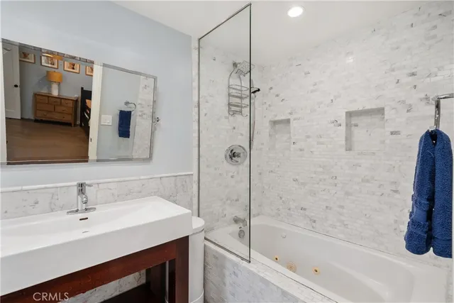 a bathroom with a tub sink and mirror
