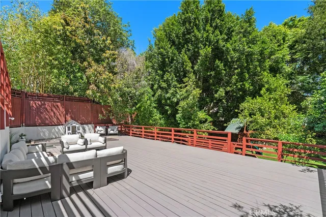 a view of a roof deck with table and chairs with wooden floor and fence