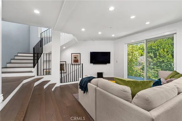a living room with furniture tv and a large window