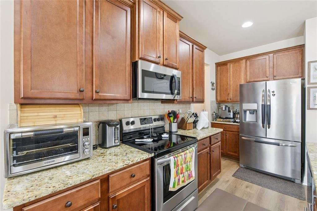 2002 Bridgewater Pass Hampton, GA 30228 - Photo 17 of 35 a kitchen with stainless steel appliances granite countertop a refrigerator a stove a sink and a microwave