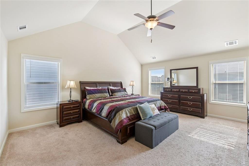 2002 Bridgewater Pass Hampton, GA 30228 - Photo 27 of 35 a spacious bedroom with a bed a dresser and a large window