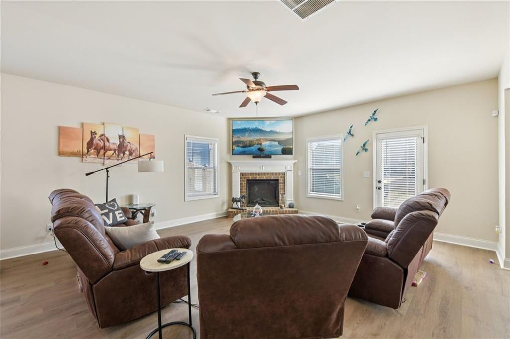 2002 Bridgewater Pass Hampton, GA 30228 - Photo 7 of 35 a living room with furniture a fireplace and a chandelier