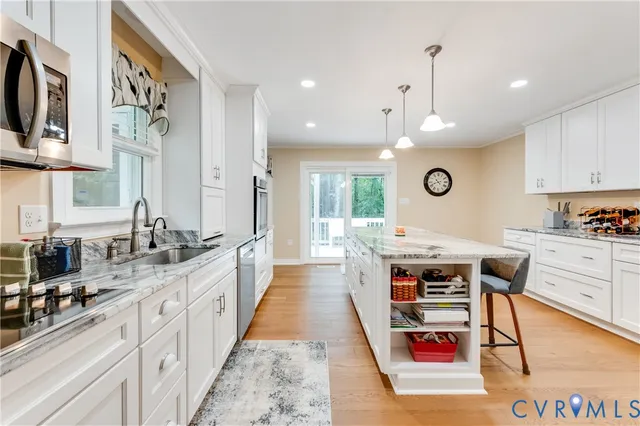 a large kitchen with stainless steel appliances granite countertop a stove a sink and a refrigerator