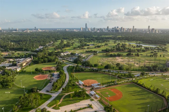 a large kitchen with stainless steel appliances kitchen island granite countertop a refrigerator and a sink