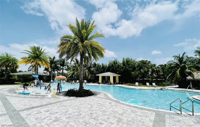 a palm tree sitting in front of a house with a yard