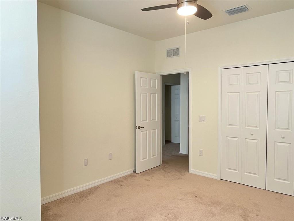 2775 Citrus Street Naples, FL 34120 - Photo 16 of 31 an empty room with closet and a chandelier fan