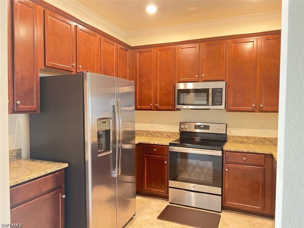 2775 Citrus Street Naples, FL 34120 - Photo 5 of 31 a kitchen with granite countertop a refrigerator stove and microwave