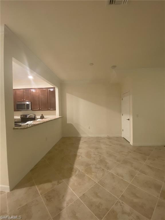 2775 Citrus Street Naples, FL 34120 - Photo 10 of 31 a view of kitchen and empty room with wooden floor