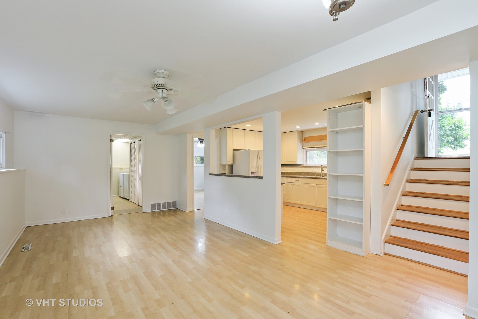 300 High Road Cary, IL 60013 - Photo 3 of 10 an empty room with wooden floor and kitchen view