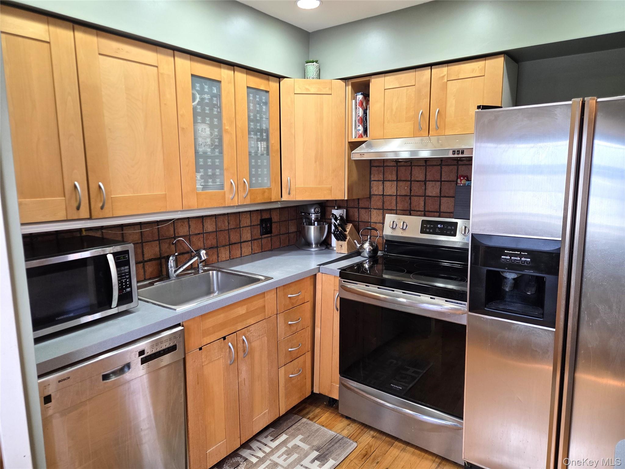655 Middle Country Road, Unit 6A2 Coram, NY 11727 - Photo 13 of 19 Another View Of The Lovely Updated Kitchen Offering Maple Cabinetry With Accent Glass Doors & Corner Cabinet, Stainless Steel Appliances (Kitchen Aid Side By Side Refrigerator With Water & Ice Maker, Frigidaire Ceramic Top Stove And Bosch Dishwasher), Recessed Lighting, Hardwood Floors & A Door To Your Own Washer & Dryer!