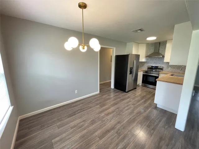 a view of a kitchen with refrigerator stove and wooden floor