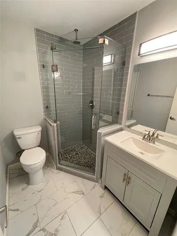 a bathroom with a granite countertop sink toilet and shower