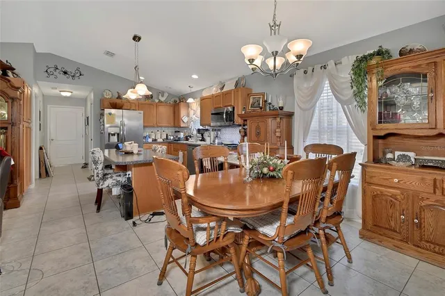 a dining room filled chandelier and wooden floor