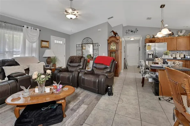a living room with furniture a chandelier and a dining room